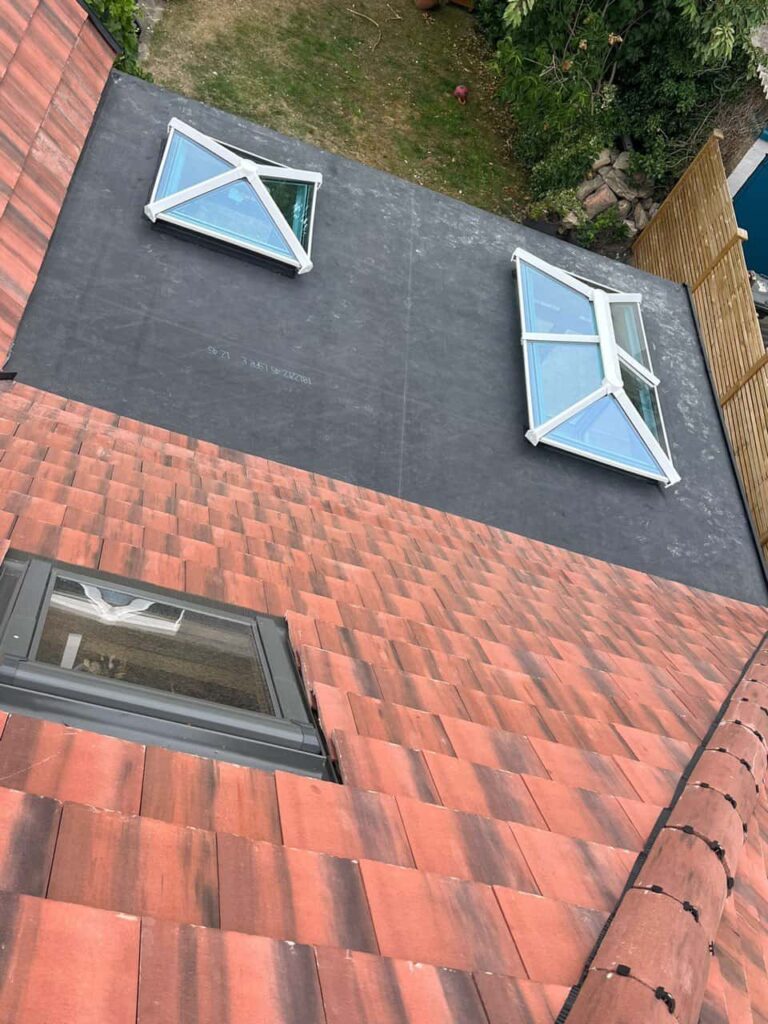 This is a photo taken from the roof ridge looking down a tiled pitched roof on to a flat roof. Works carried out by Market Harborough Roofing Repairs
